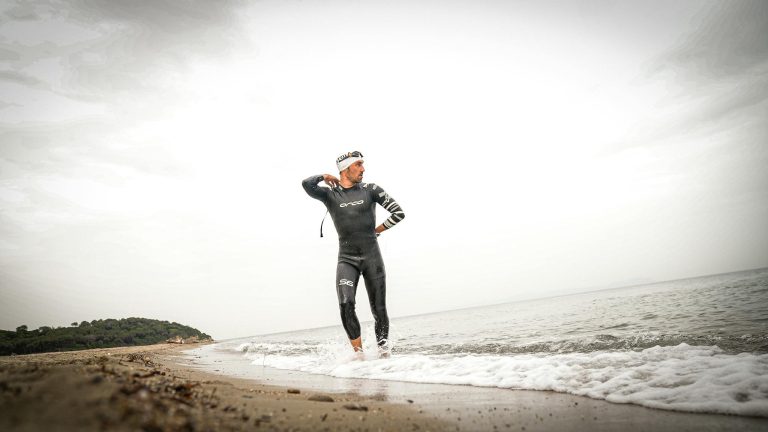 Triathlete preparing for swim in wetsuit at Gelibolu, capturing determination and readiness.